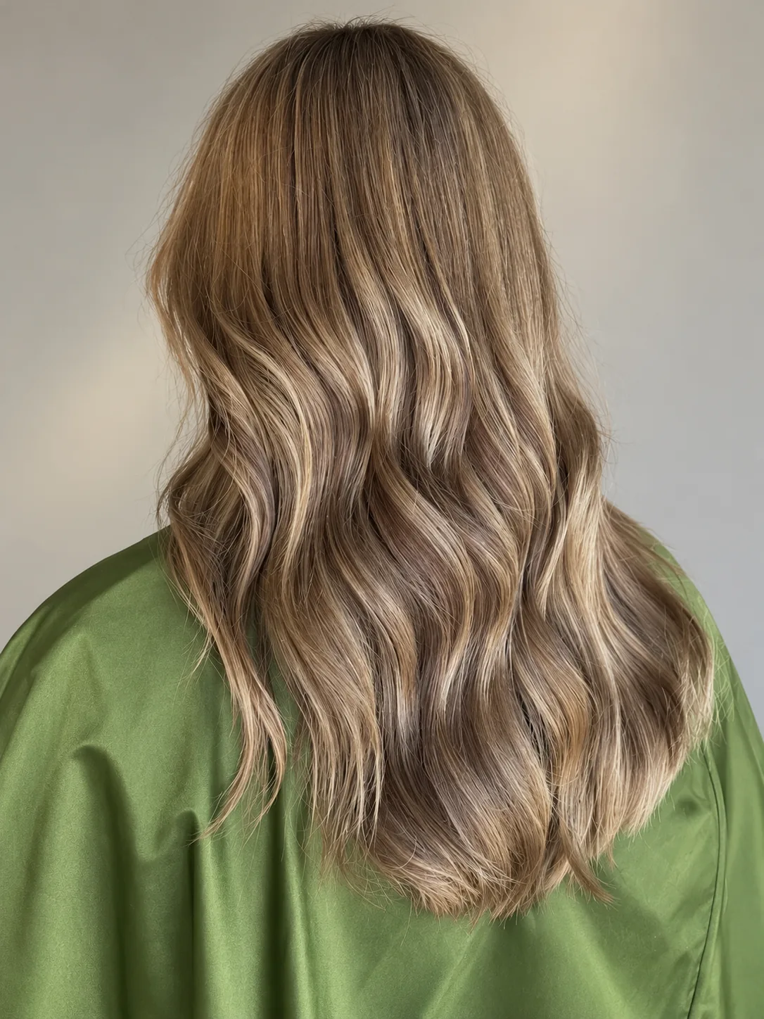 Long balayage hair extensions in soft waves, seen from behind